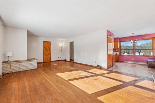 living room with a baseboard heating unit, hardwood / wood-style floors, and a notable chandelier