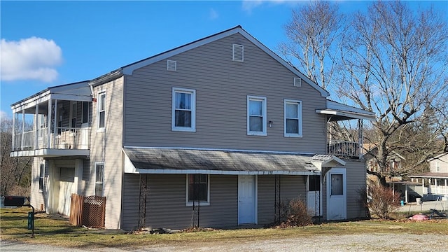 back of house with a balcony and a sunroom