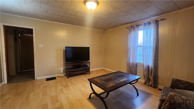 living room with crown molding and light hardwood / wood-style floors