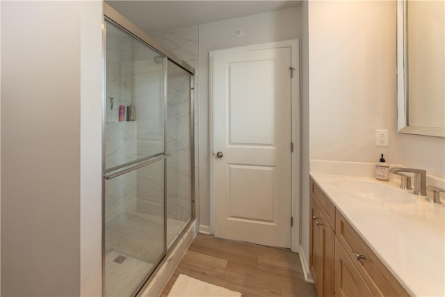 bathroom featuring walk in shower, vanity, and hardwood / wood-style flooring