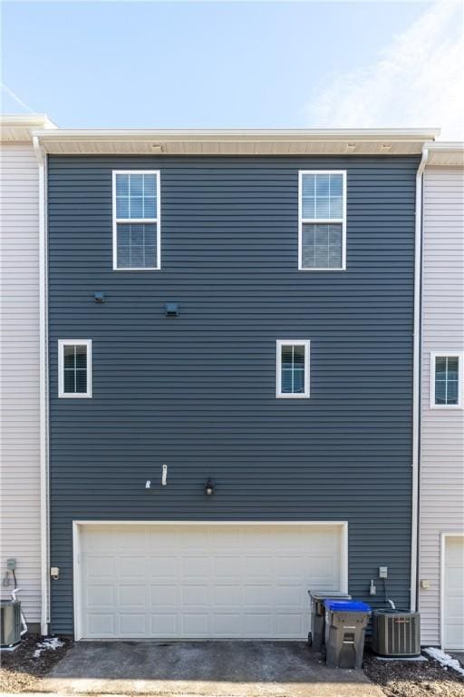 view of side of home featuring a garage and central AC unit