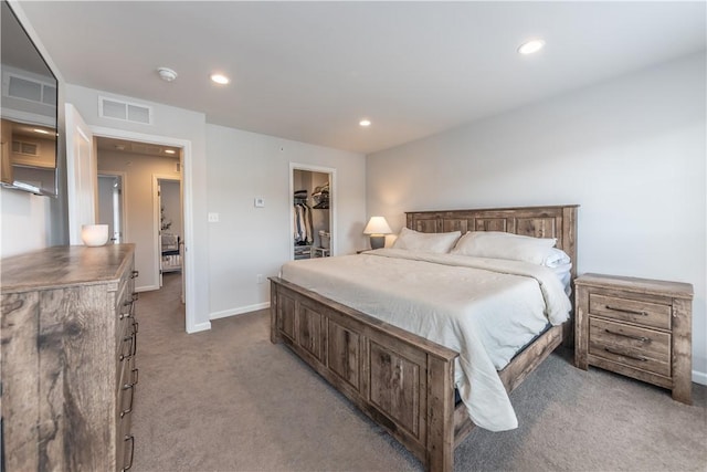 carpeted bedroom with a walk in closet