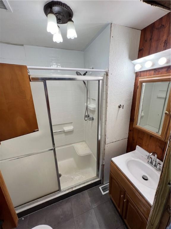 bathroom with vanity, an enclosed shower, and tile patterned flooring