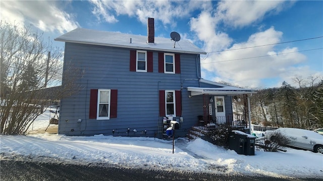 view of snow covered rear of property