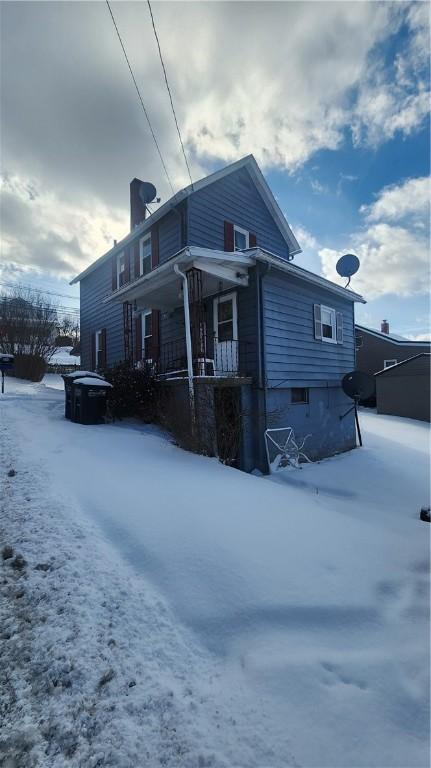 snow covered house with a porch