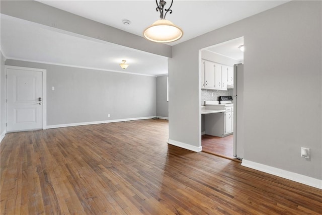 unfurnished living room with crown molding and dark hardwood / wood-style floors