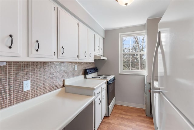 kitchen with white cabinetry, light hardwood / wood-style floors, white appliances, and decorative backsplash