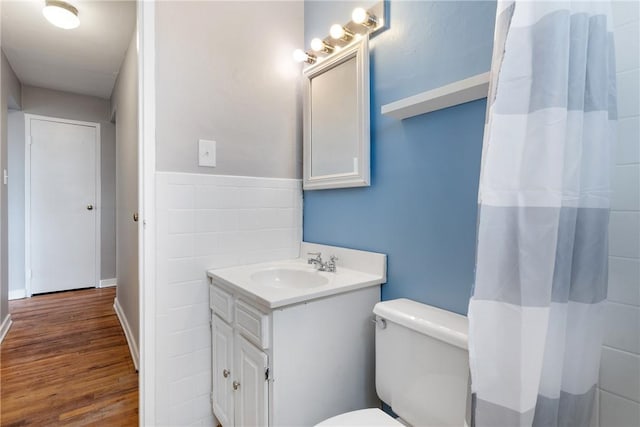 bathroom with vanity, wood-type flooring, tile walls, and toilet