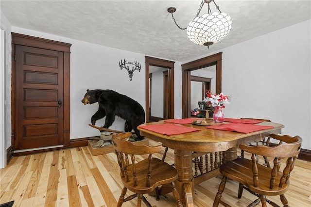 dining area featuring a textured ceiling and light wood-type flooring