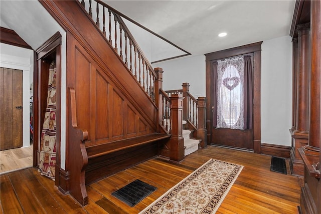 foyer entrance featuring wood-type flooring and decorative columns