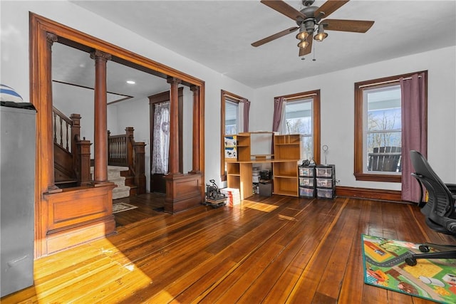 interior space featuring decorative columns, dark hardwood / wood-style floors, and ceiling fan