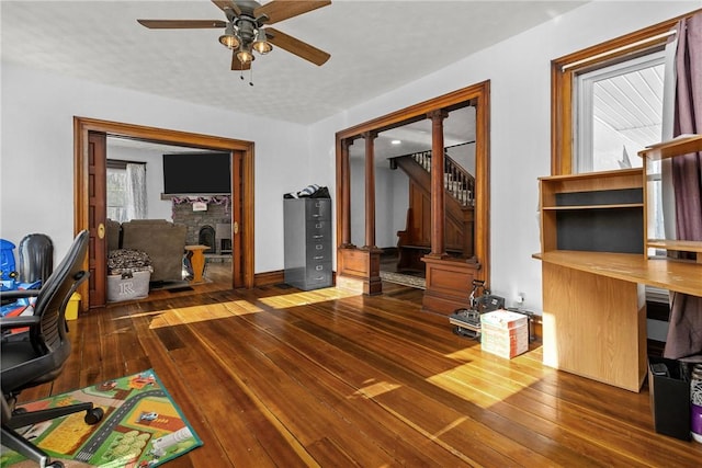 office space featuring hardwood / wood-style flooring, ceiling fan, and a fireplace