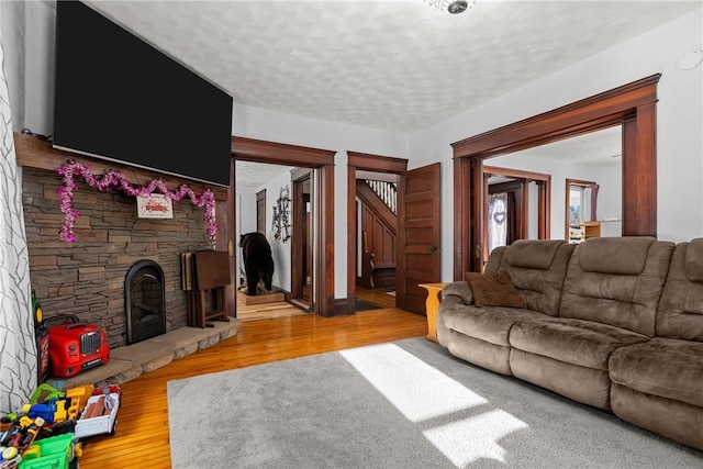 living room with hardwood / wood-style floors, a fireplace, and a textured ceiling