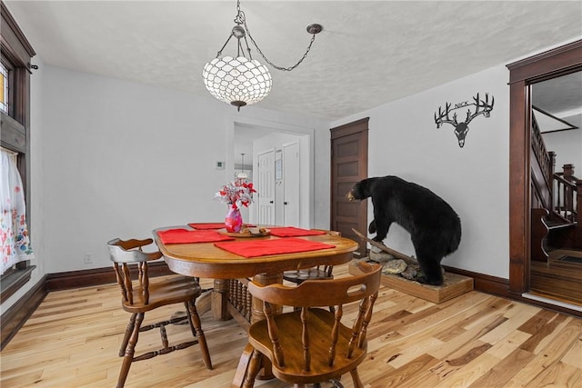 dining room with a textured ceiling and light hardwood / wood-style floors