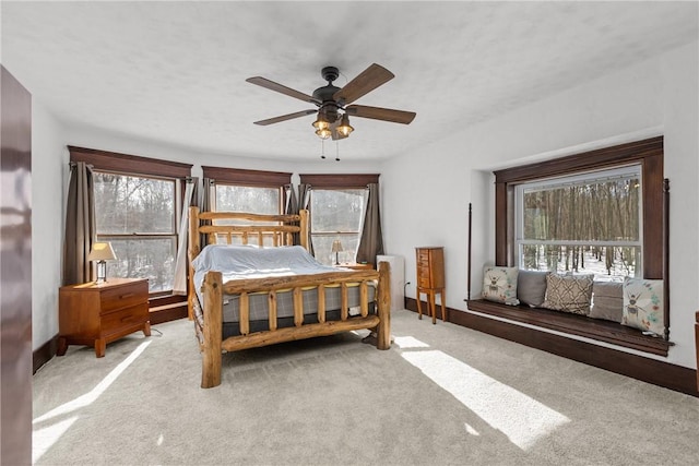 bedroom with ceiling fan and light carpet