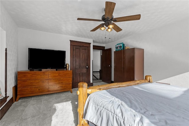 bedroom with light carpet, a textured ceiling, and ceiling fan