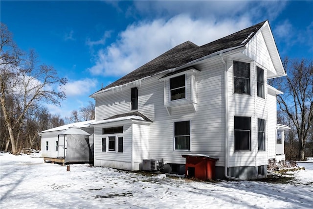 snow covered property with central AC