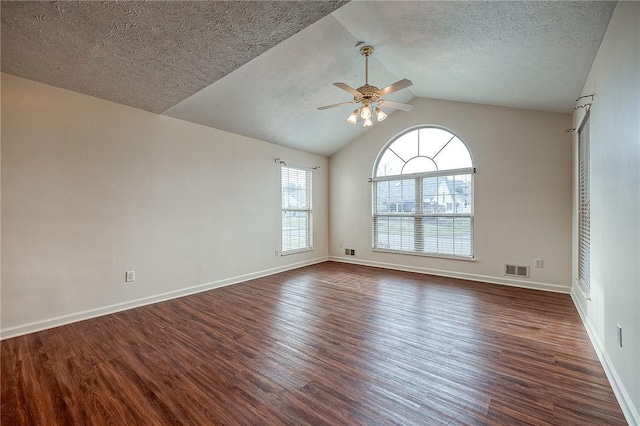 spare room featuring ceiling fan, dark hardwood / wood-style flooring, vaulted ceiling, and a textured ceiling