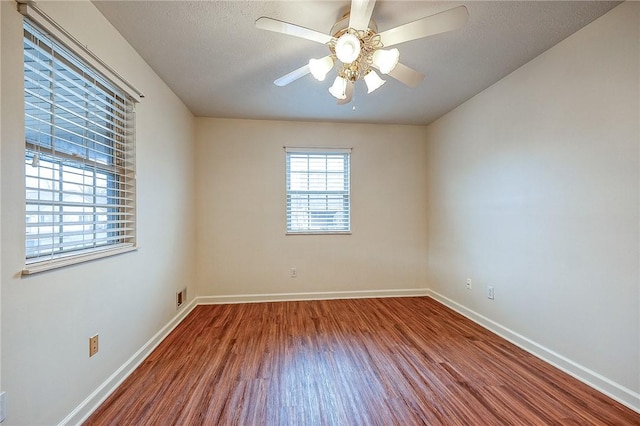 spare room featuring wood-type flooring, a textured ceiling, and ceiling fan