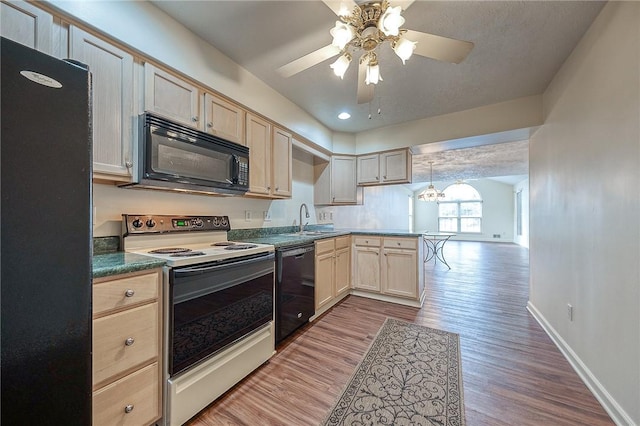 kitchen with decorative light fixtures, sink, black appliances, light brown cabinets, and light wood-type flooring