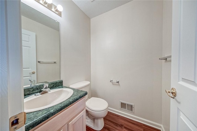 bathroom with vanity, hardwood / wood-style floors, and toilet