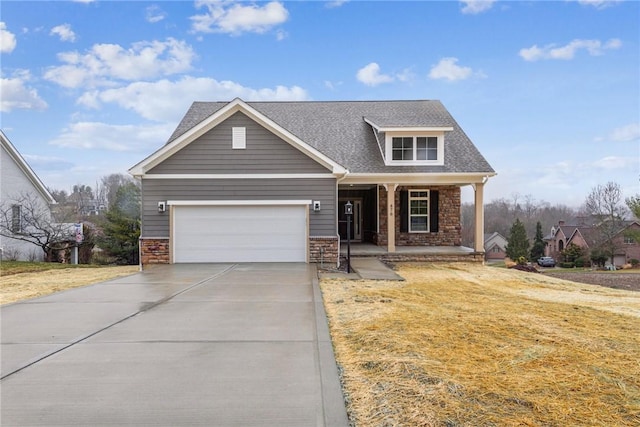 view of front of property with a front yard, an attached garage, covered porch, a shingled roof, and concrete driveway