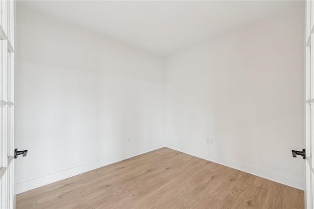 empty room with a wealth of natural light, baseboards, and light wood-style flooring