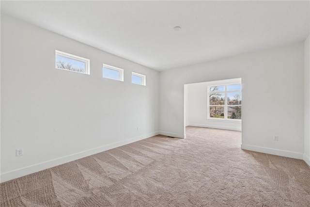 carpeted empty room featuring baseboards