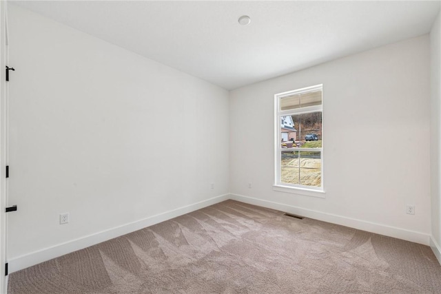 carpeted empty room with visible vents and baseboards