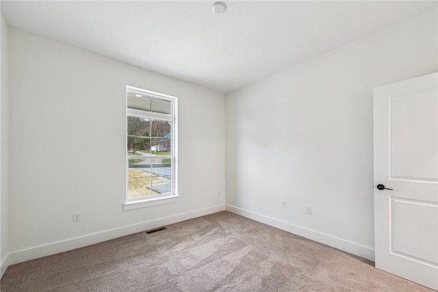 carpeted empty room featuring visible vents and baseboards