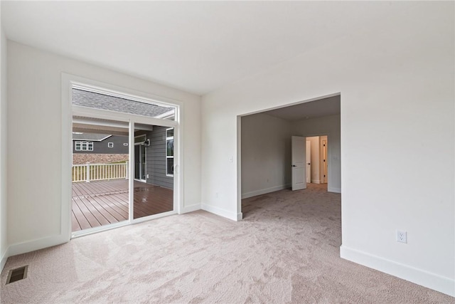 carpeted empty room with baseboards and visible vents