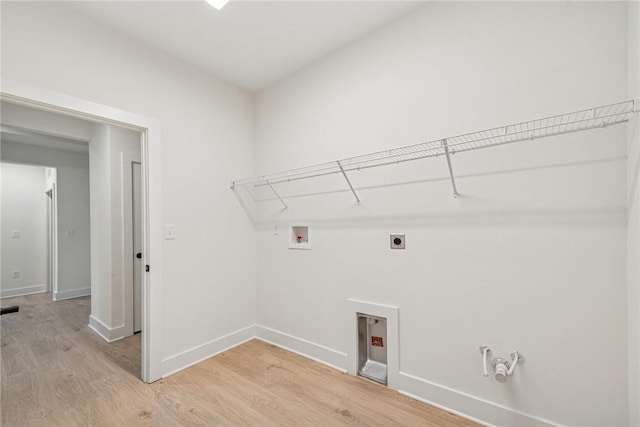 laundry area with electric dryer hookup, washer hookup, hookup for a gas dryer, light wood finished floors, and baseboards