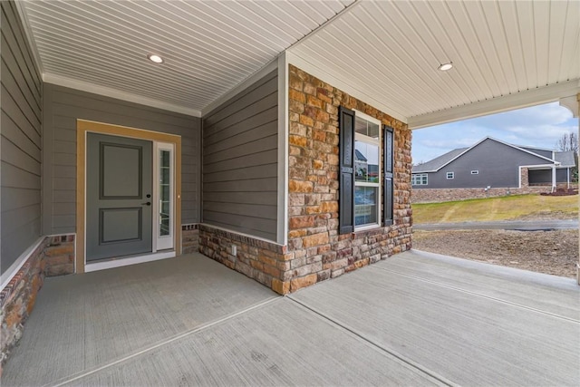 entrance to property with covered porch and stone siding