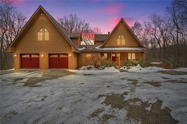 rustic home featuring covered porch, driveway, and a shingled roof