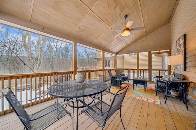 sunroom featuring lofted ceiling and a ceiling fan