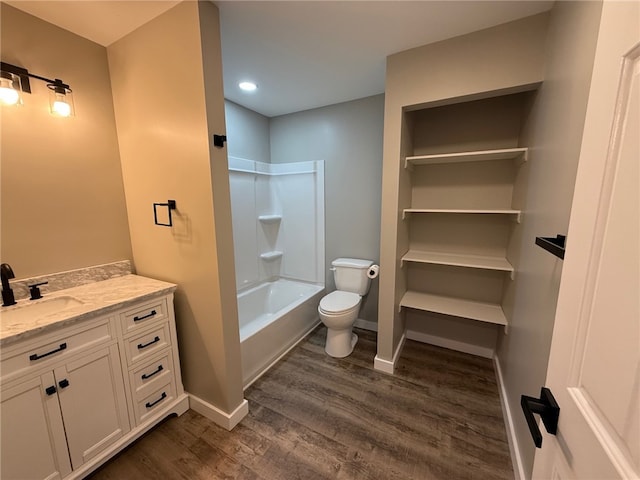 full bathroom featuring vanity, wood-type flooring, washtub / shower combination, and toilet