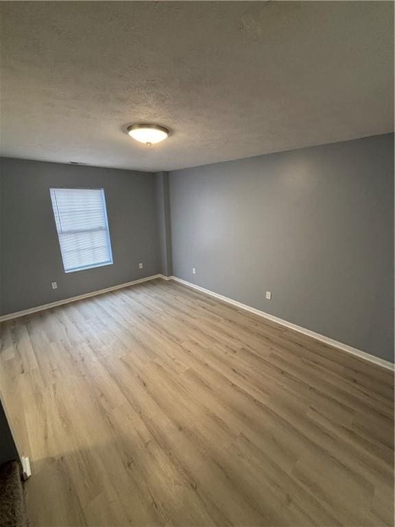 spare room with hardwood / wood-style floors and a textured ceiling