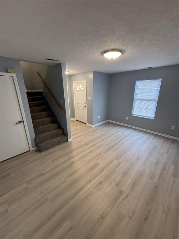 interior space with light hardwood / wood-style floors and a textured ceiling