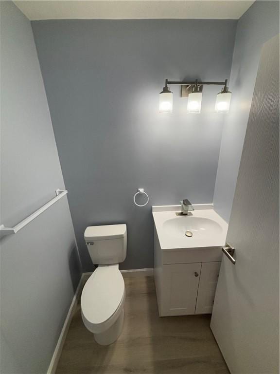 bathroom featuring vanity, hardwood / wood-style flooring, and toilet