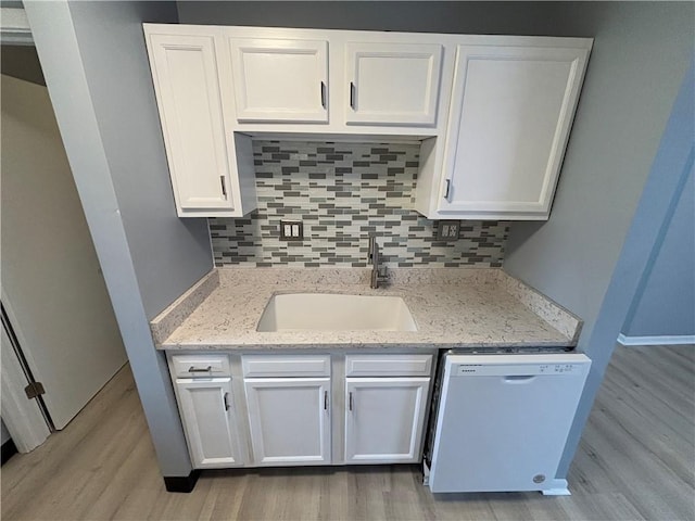 kitchen with sink, dishwasher, light stone countertops, decorative backsplash, and white cabinets