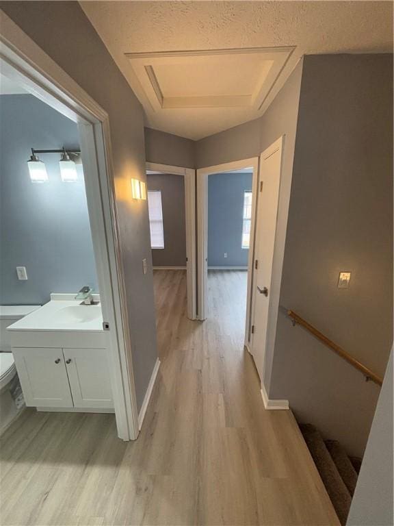 hallway featuring sink and light wood-type flooring