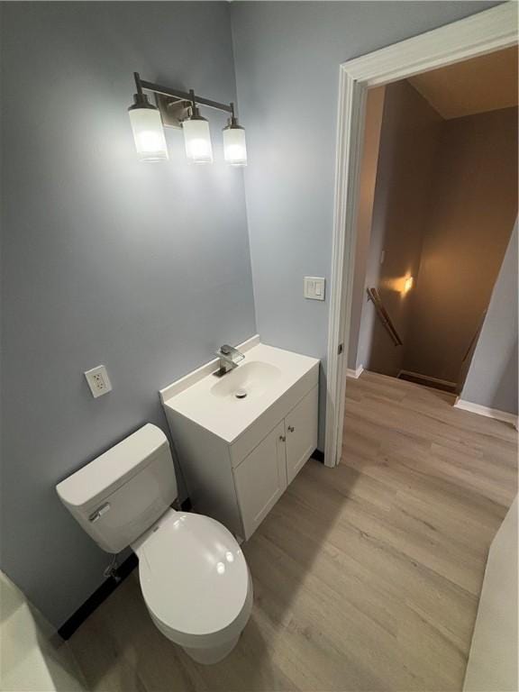 bathroom with vanity, hardwood / wood-style flooring, and toilet