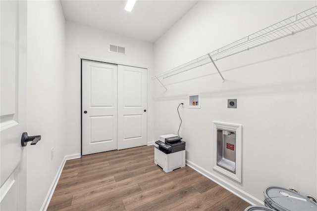 laundry area with hookup for a washing machine, laundry area, wood finished floors, visible vents, and baseboards