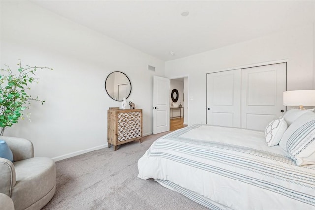 bedroom featuring light carpet, a closet, visible vents, and baseboards