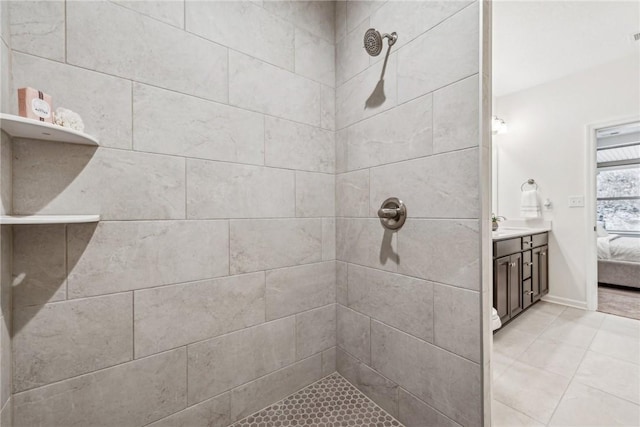 full bath featuring connected bathroom, tiled shower, and vanity