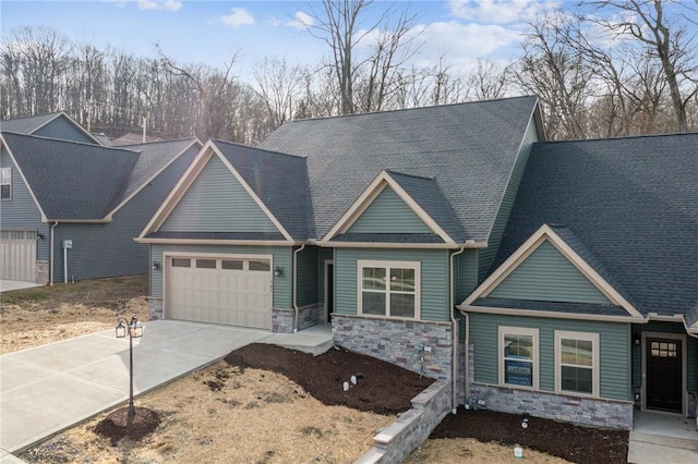 craftsman house featuring stone siding, concrete driveway, roof with shingles, and an attached garage