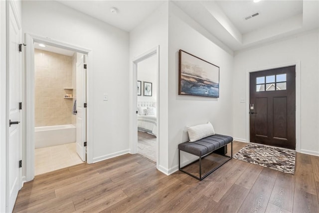 entrance foyer featuring baseboards, visible vents, and hardwood / wood-style floors