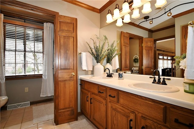 bathroom featuring tile patterned flooring, crown molding, and vanity