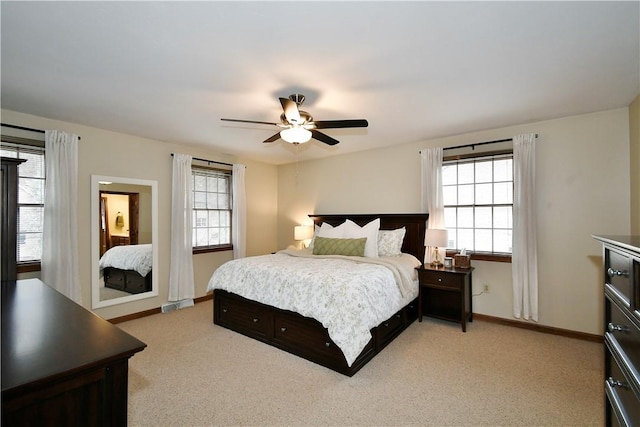 bedroom featuring multiple windows, light colored carpet, and ceiling fan