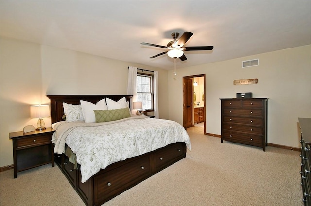 bedroom with connected bathroom, light carpet, and ceiling fan